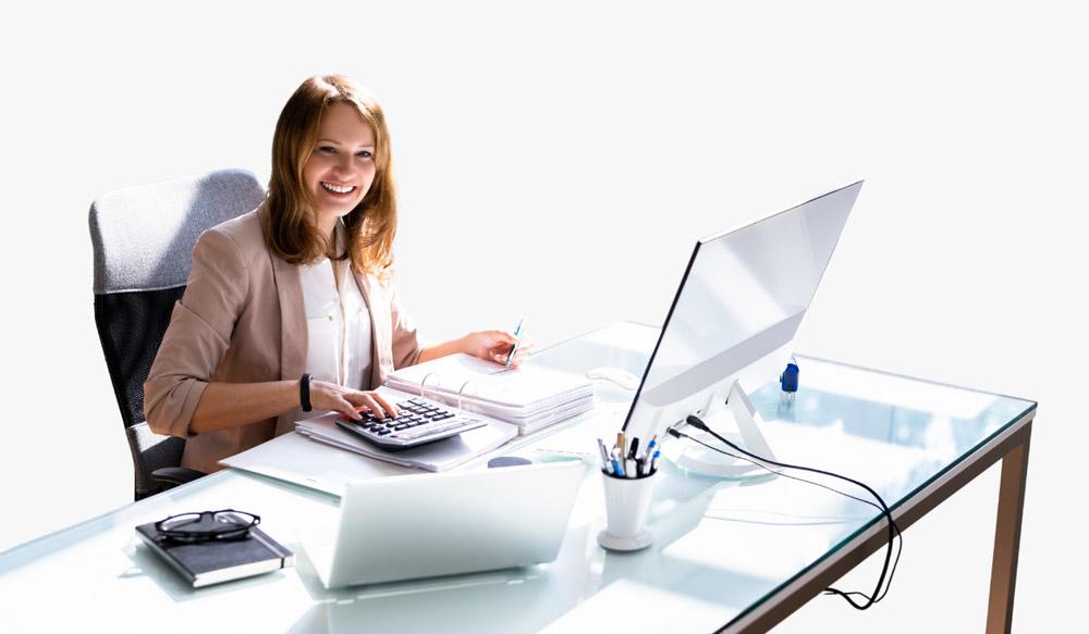 An alumni sits as a CPA behind their desk.